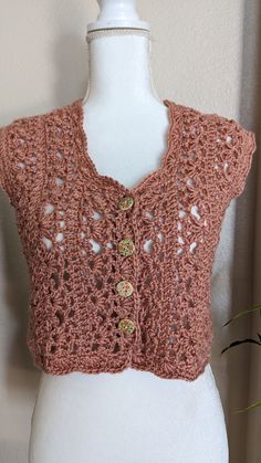 a white mannequin with a pink crochet top on it's torso