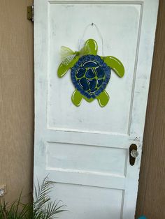 a door with a turtle painted on it and a potted plant next to it