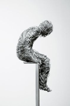 a wire sculpture sitting on top of a metal pole