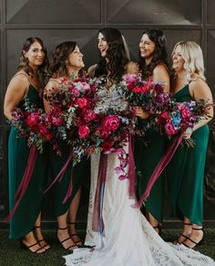 a group of women standing next to each other holding bouquets