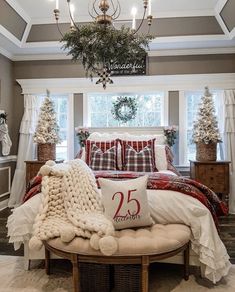 a bedroom decorated for christmas with red and white decor, plaid bedding, pillows, and wreaths