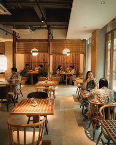 people sitting at wooden tables in a restaurant