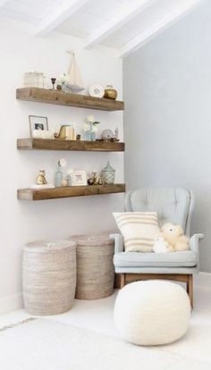 a room with some shelves on the wall and a teddy bear in a chair next to it