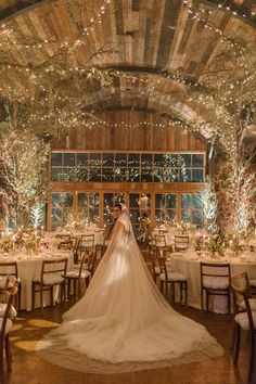 a bride and groom are standing in front of their wedding reception tables at the barn