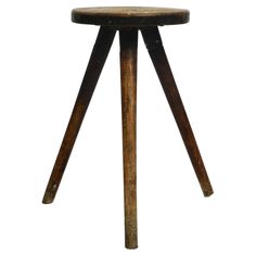 an old wooden stool with two legs and a round seat on the bottom, against a white background