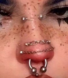 a woman with piercings on her nose and nose ring