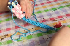 a child is playing with an object on the table and it's blue string