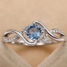 a white gold ring with an aqua topazte and diamond accents