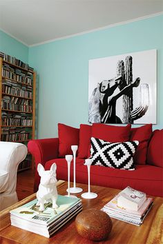 a living room with red couches and bookshelves