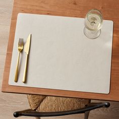 a placemat with a fork and knife on it next to a glass of water