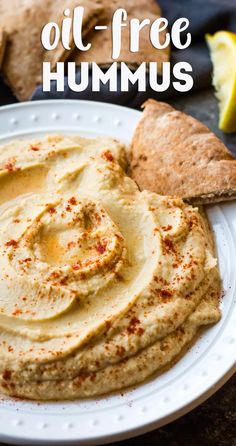 hummus on a white plate with pita bread