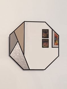 a mirror that is on the wall with some pictures hanging from it's sides