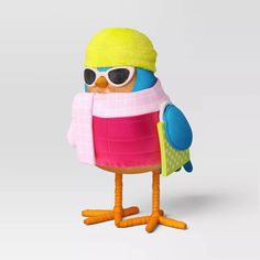 a stuffed bird wearing sunglasses and a hat with a scarf around it's neck