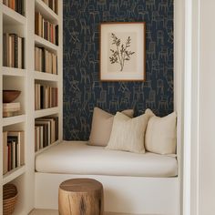 a white couch sitting next to a bookshelf filled with lots of book shelves