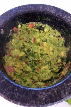 a bowl filled with guacamole sitting on top of a table