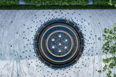 an aerial view of a circular fountain surrounded by trees