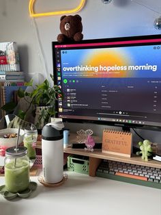 a desktop computer monitor sitting on top of a desk next to a cup and other items