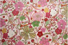 a pink and green floral print on white fabric with red, orange, yellow, and green flowers