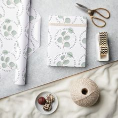 wrapping paper, twine and other craft supplies laid out on top of a table