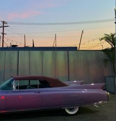 a purple car parked in front of a fence