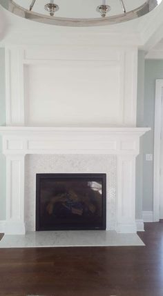 a living room with a fire place and ceiling fan in the middle of the room