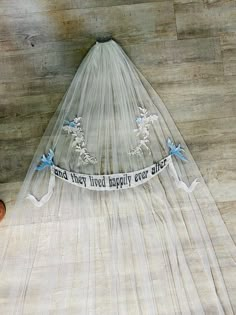 a veil with blue flowers on it and the words and they lived happily ever after