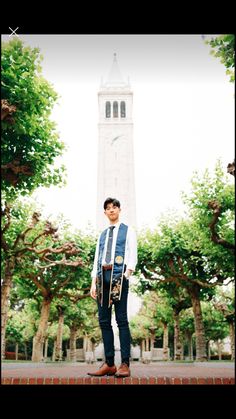 a man standing in front of a tall clock tower