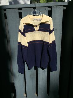 Men's sweater mainly white, and navy blue, with brown stripes. The sweater size is a large, and could fit a medium to large body type. This could be used in combination with a navy blue pair of pants. The sweater would also l look nice with a brown pair of slacks to bring out the small lines on the shirt, and wingtip shoes. We just can't get enough of the fancy vintage clothing. AzucarSugar is happy to bring such great vintage clothes.  . . . . . . . . . . . . . . . . . #oldschool #shirt #pullover #sweater #70s #1970s #vintagemens #mens #fashionable #vintagefasion #mensfashion #fashion #mensclothing #realvintage #vintage #retro #businessattire #business #style #vintageclothing #dapper #dapperdresser #classy #classic #upscale #instagood #clothingboutique #boutique #nice Please note all sale Navy Casual Sweater With Contrast Stripes, Classic Winter Tops With Contrast Stripes, Navy Top With Contrast Stripes For Fall, Striped Polo Sweater For Fall, Vintage Navy Top For Fall, Navy Retro Top For Fall, Vintage Navy Sweater With Long Sleeves, Navy Vintage Long Sleeve Sweater, Blue Shirt Brown Pants