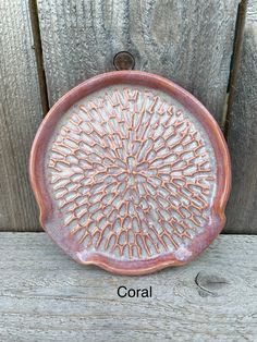 a decorative dish is shown with the word coral written in english and an image of a sunburst on it