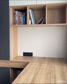 a wooden desk with some books on top of it and a book shelf in the corner