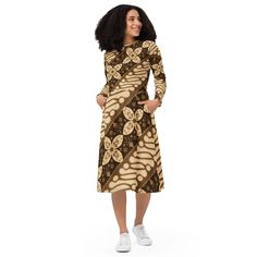 Step into the enchanting world of fashion with our exquisite Batik Design Long Sleeve Midi Dress - a perfect gift for her that seamlessly combines comfort and style. This winter dress features a captivating batik design in brown, creating a unique and eye-catching ensemble. The long sleeves provide warmth during colder months, making it an ideal choice for a thoughtful and fashionable present. Elevate her wardrobe with this stunning piece that effortlessly blends the beauty of batik with the timeless charm of a midi dress. Designed with a flattering cut, fitted waist, and a flair bottom, this dress accentuates your silhouette in all the right places. The fitted waist offers a feminine touch, while the flair bottom adds a playful and graceful movement to your every step. Embrace both style Elegant Long Sleeve Dresses With Batik Print, Elegant Long Sleeve Batik Print Dresses, Casual Brown Dress With Batik Print, Casual Brown Batik Print Dress, Casual V-neck Batik Print Maxi Dress, Festive Long-sleeve Batik Print Dress, Flowy V-neck Batik Print Dress, Spring V-neck Batik Print Maxi Dress, Mode Batik