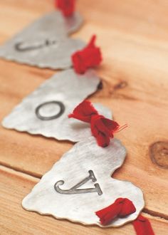 two metal tags with red thread on them sitting on a wooden table next to each other