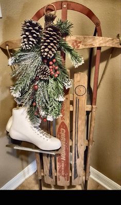 an old sled with pine cones, evergreen and skis in it is sitting on the floor