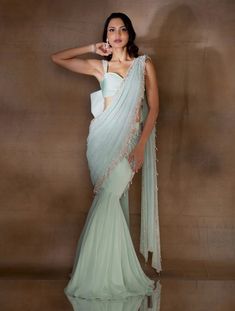 Mint georgette fishtail sari featuring an attached pre-draped pallu hand embellished with ivory pearls & glass beads & tassles. Paired with a stylised organza crop with embellished straps & an oversized bow at the back.From Shloka Khialani's Winter Sun collection.DELIVERY TIMEPlease allow 6-8 weeks for your outfit to arrive.FABRIC DETAILSGeorgette, Organza, CrepeProfessional cleaning only. Traditional Georgette Pre-draped Saree With Pearl Embroidery, Elegant Draped Organza Saree, Traditional Pre-draped Saree With Pearl Embroidery For Evening, Festive Hand Embellished Organza Pre-draped Saree, Floor-length Georgette Pre-draped Saree For Reception, Floor-length Georgette Saree For Reception, Hand Embellished Organza Pre-draped Saree, Reception Saree With Pearl Embroidery And Traditional Drape, Traditional Drape Saree With Pearl Embroidery For Reception