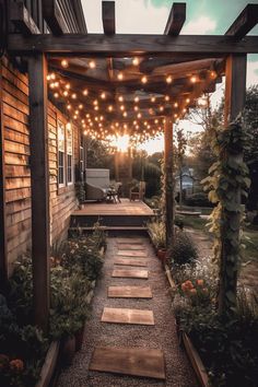 an outdoor patio with lights strung from the ceiling and wooden steps leading up to it