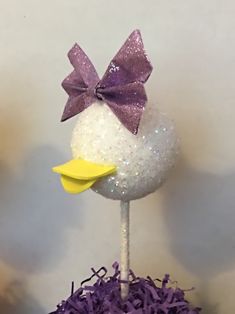 a cake topper with a purple bow on it