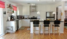 a kitchen with wooden floors and white cabinets