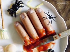 some hot dogs are on a plate with condiments and halloween decorations around them