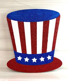 a red, white and blue top hat with stars on the side sitting on a wooden surface