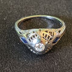 a silver ring sitting on top of a black table next to a brown carpeted floor