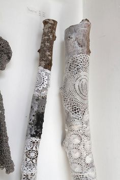 two pieces of art made out of lace and wood sticks on a white surface with one piece cut in half