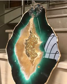 a green and gold plate sitting on top of a white counter next to a stair case