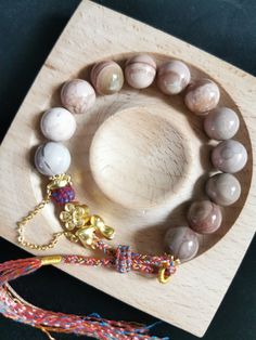 This beautiful bracelet has 12 pink-grey-toned pastel round beads. Number 12 symbolizes the twelve links of dependent origination in Buddhism, linking the circle of life. The beads used are made from fully natural and authentic Alashan agate. The metal parts are copper based gold plated alloy. The bracelet is not stretchy, but it has a fully handmade adjustable weaved strap, so it will fit most wrist sizes. As a reference, my wrist (as shown in the picture and video) is 16cm. The Alashan agate i Alashan Agate Bracelet, Dependent Origination, Crystal Bracelets Diy, Agate Bracelet, Circle Of Life, Lovely Jewellery, Present Gift, Dream Jewelry, Stone Bracelet