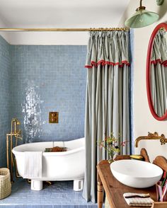 a bath room with a tub a sink and a mirror on the wall next to a table