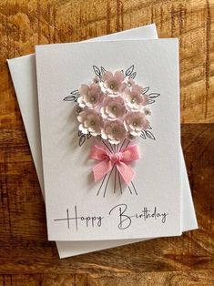 a happy birthday card with pink flowers and a bow on the front that says, happy birthday