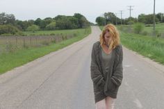 a woman is walking down the road with her foot in the air while wearing pink tights