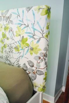 an upholstered headboard with green and blue flowers on it