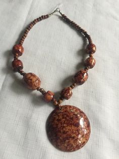 "Brown and beige marbled resin statement necklace. The central pendant is 2.75\" and it's surrounded by matching beads of different shapes and sizes. Very earthy, organic career look, but also works with jeans. Measures 20\" long. Also, please take a look at my storefront at: https://www.etsy.com/shop/FabFinds42?ref=seller-platform-mcnav I have a wide selection of one-of-a-kind items, from clothing and toys to home decor and gift items, and I add new things almost every day." Earthy Brown Jewelry With Large Beads, Handmade Brown Earthy Necklaces, Earthy Brown Necklace With Large Beads, Brown Shell Necklace With Round Beads For Gift, Handmade Earthy Brown Necklace, Bohemian Resin Round Pendant Necklace, Earthy Hand-strung Brown Beaded Necklaces, Bohemian Resin Pendant Necklaces, Unique Brown Resin Necklaces