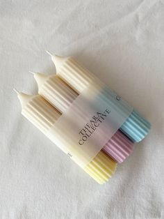 four different colored toothbrushes sitting on top of a white sheet