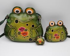 Save 10% off on the frog family bundle! This set includes 1 cross-body bag, 1 cute coin purse, and 1 baby frog key chain. They make great gifts for anyone who loves frogs or collects frogs.  Coin purse: 3" X 4" x 1" Cross-body bag: 7"L X 5"H X 1"W Key chain: 2"L X 1.5"H Zipper closure for both of frog purses. A wristlet strap attached with the frog coin purse and a adjustable long strap for large purse.  Crafted from high-quality leather, this charming frog-shaped bundle is the perfect blend of Handmade Green Coin Purse For Gift, Handmade Green Coin Purse As Gift, Fun Green Bags For Gifts, Hand Painted Green Bags For Gift, Green Hand Painted Bags For Gift, Green Hand-painted Bag As Gift, Green Novelty Bags For Gifts, Cute Green Coin Purse For Daily Use, Handmade Green Coin Purse For Travel